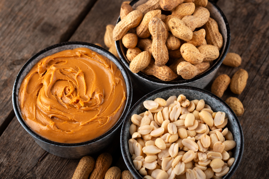 Creamy peanut butter in a bowl with peanuts and roasted nuts